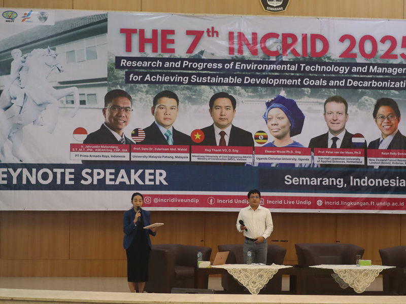 A person and person standing in front of a bannerAI-generated content may be incorrect.