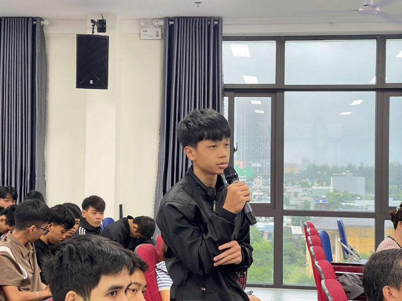 A child holding a microphone in front of a group of peopleDescription automatically generated