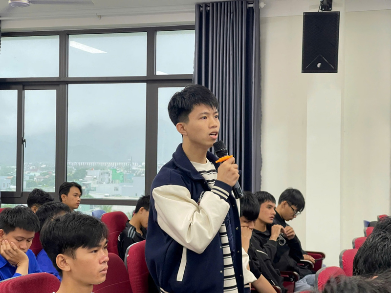 A person holding a microphone in front of a group of peopleDescription automatically generated